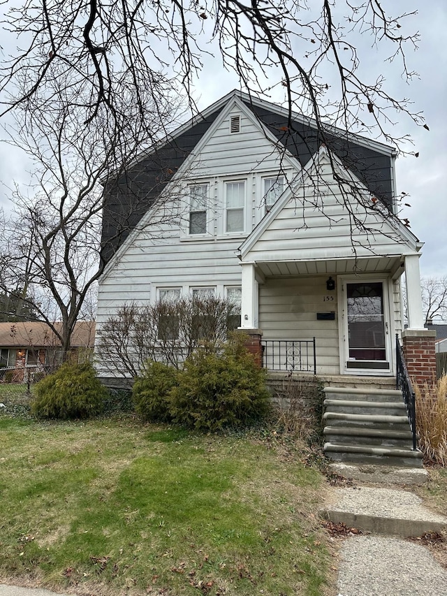 view of front of property with covered porch and a front lawn