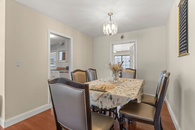 dining area featuring dark hardwood / wood-style flooring, plenty of natural light, and a chandelier