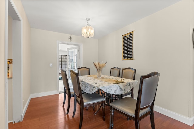 dining space with wood-type flooring and a notable chandelier