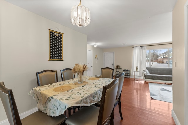 dining room with hardwood / wood-style floors and an inviting chandelier