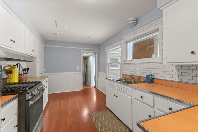 kitchen featuring gas stove, hardwood / wood-style flooring, white cabinetry, and sink