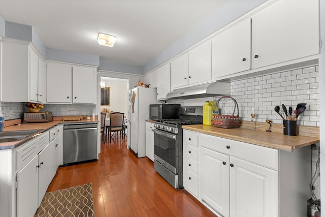 kitchen featuring sink, backsplash, hardwood / wood-style floors, white cabinets, and appliances with stainless steel finishes