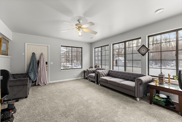 living room featuring carpet floors, ceiling fan, and a healthy amount of sunlight