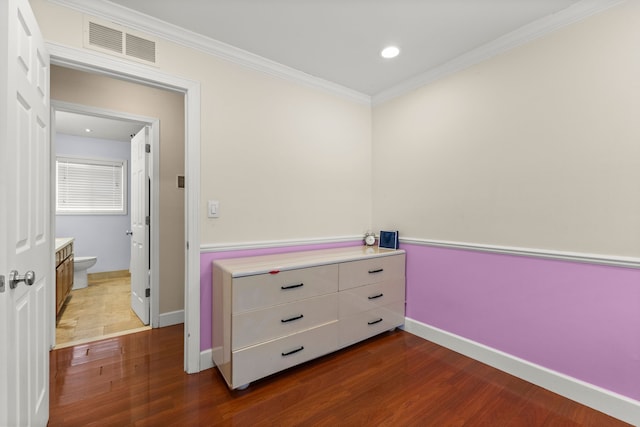 bedroom with ensuite bath, crown molding, and dark hardwood / wood-style floors