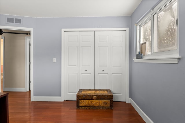 bedroom featuring dark hardwood / wood-style floors and a closet