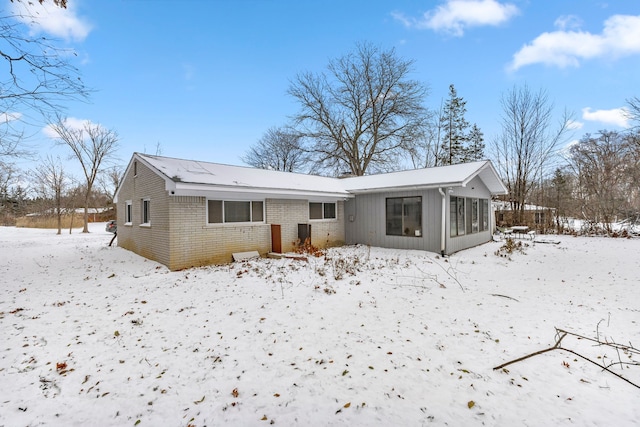 view of snow covered back of property