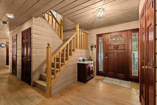 foyer featuring wood ceiling, light hardwood / wood-style floors, and wood walls