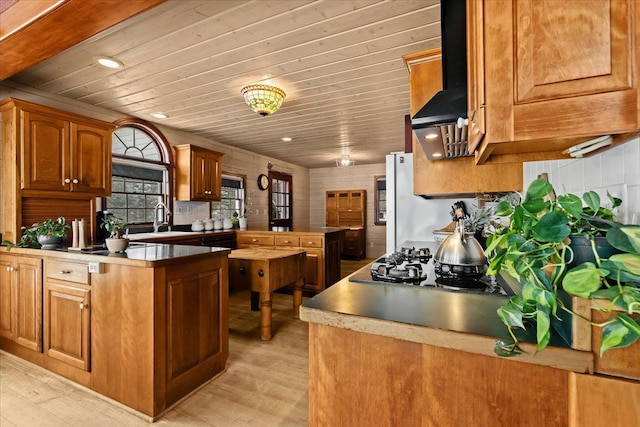 kitchen with wood ceiling, kitchen peninsula, ventilation hood, light wood-type flooring, and sink