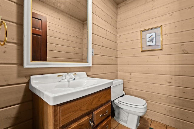 bathroom featuring vanity, tile patterned floors, and wooden walls