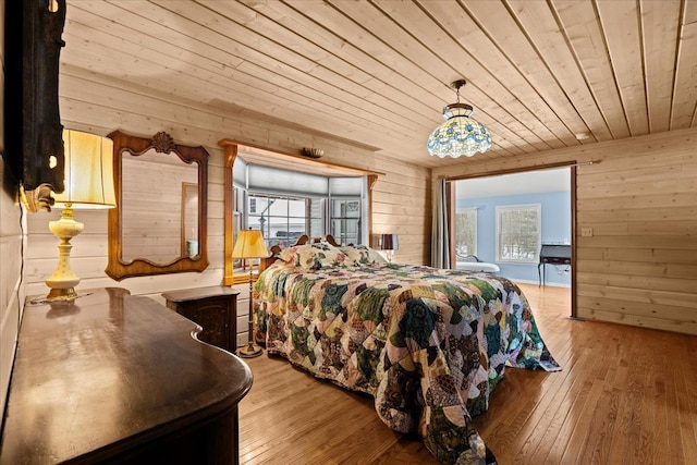 bedroom featuring light wood-type flooring, wood ceiling, and wooden walls