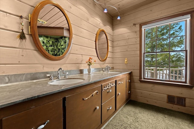 bathroom with vanity and wooden walls