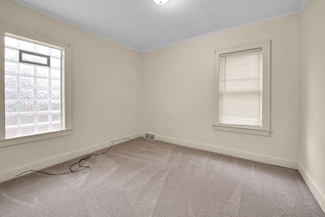 carpeted empty room featuring crown molding