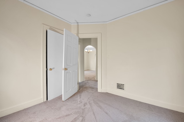 carpeted spare room featuring ornamental molding