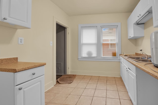 kitchen with sink, white cabinets, and light tile patterned flooring