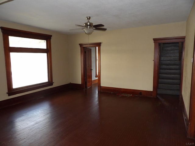 empty room with dark hardwood / wood-style flooring and ceiling fan