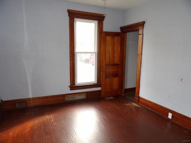 spare room featuring dark hardwood / wood-style floors and plenty of natural light