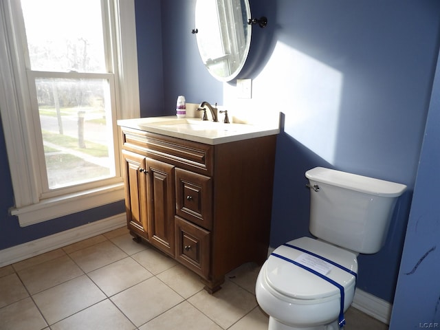 bathroom featuring vanity, plenty of natural light, tile patterned flooring, and toilet