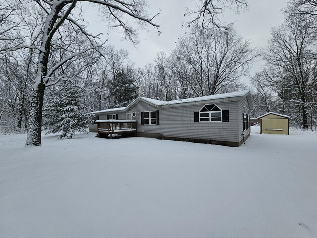 view of front facade featuring a deck, a garage, and an outdoor structure