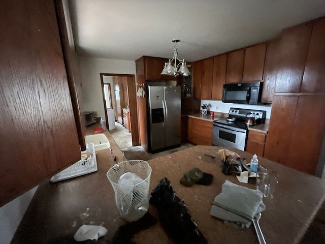 kitchen featuring sink, pendant lighting, a notable chandelier, and appliances with stainless steel finishes