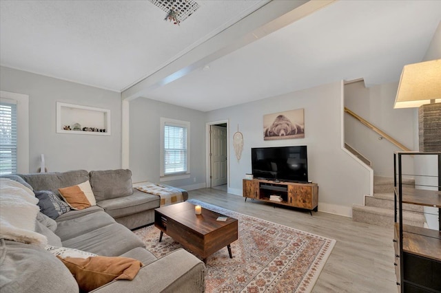 living room featuring beam ceiling and light hardwood / wood-style floors