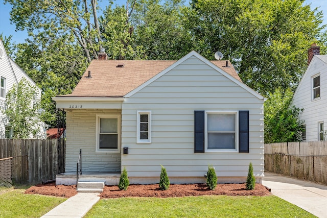 bungalow-style house with a front lawn