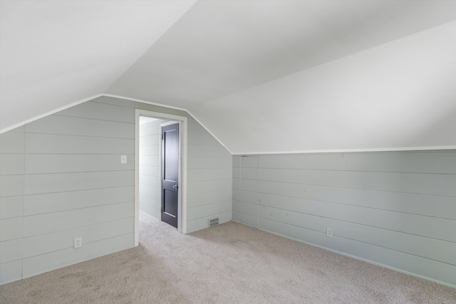 bonus room featuring light colored carpet and vaulted ceiling