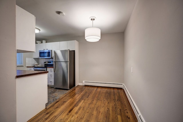 kitchen with dark hardwood / wood-style floors, tasteful backsplash, white cabinetry, stainless steel appliances, and a baseboard radiator