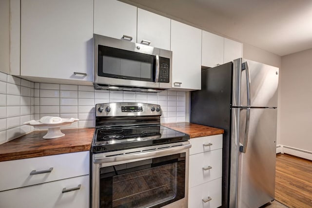 kitchen with butcher block counters, stainless steel appliances, backsplash, light hardwood / wood-style floors, and white cabinets