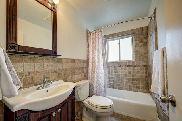 full bathroom featuring shower / bath combo, vanity, toilet, and tile walls