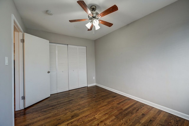 unfurnished bedroom featuring ceiling fan, dark hardwood / wood-style floors, and a closet