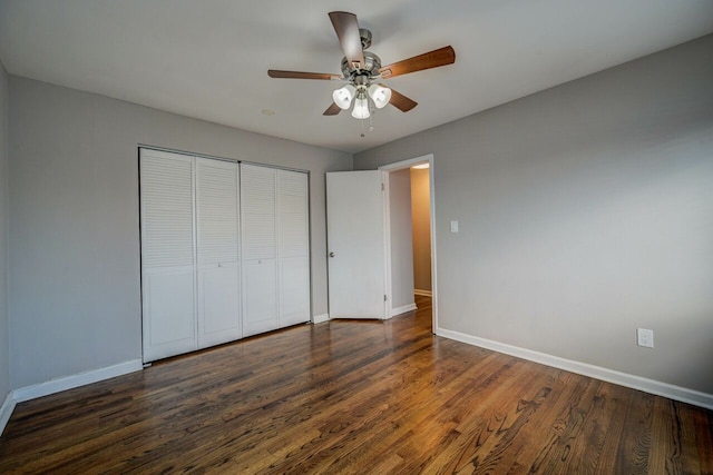 unfurnished bedroom with ceiling fan, a closet, and dark wood-type flooring