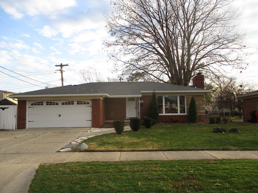 ranch-style home with a front lawn and a garage