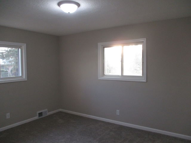 carpeted empty room featuring a textured ceiling