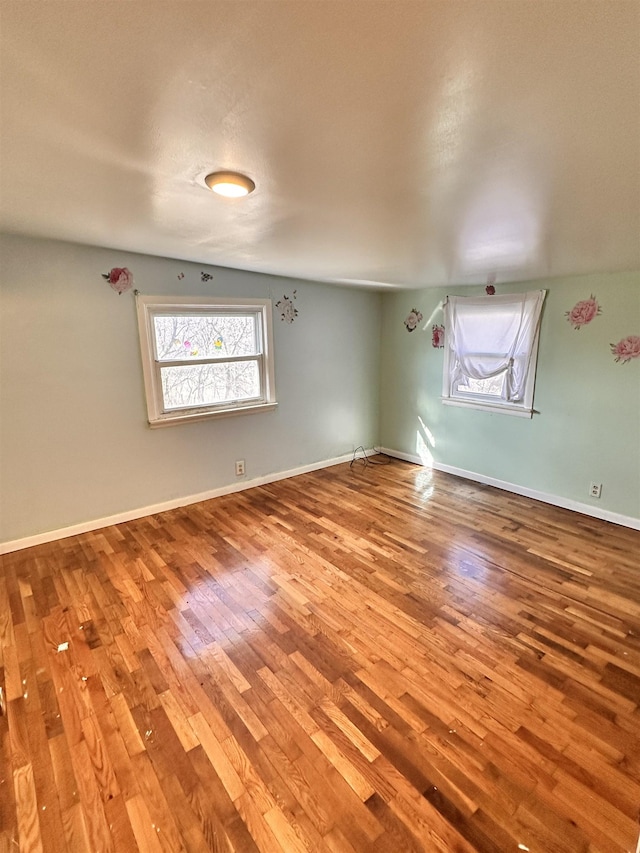 empty room with a textured ceiling, wood-type flooring, and vaulted ceiling