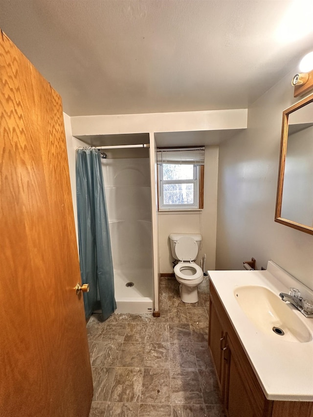 bathroom featuring toilet, vanity, and a shower with shower curtain