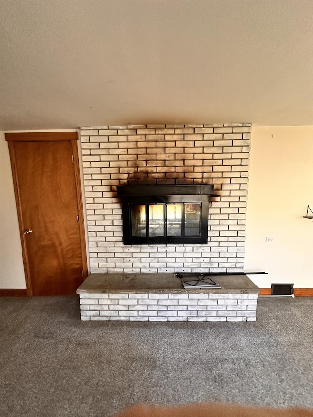 interior details with carpet flooring, a textured ceiling, and a brick fireplace