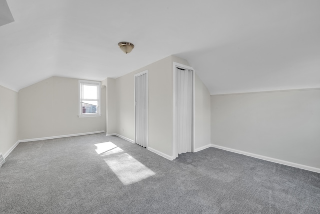 bonus room featuring vaulted ceiling and dark colored carpet