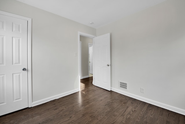 unfurnished bedroom featuring dark hardwood / wood-style floors