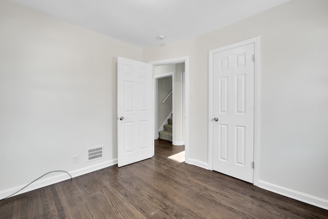 unfurnished bedroom with dark hardwood / wood-style floors