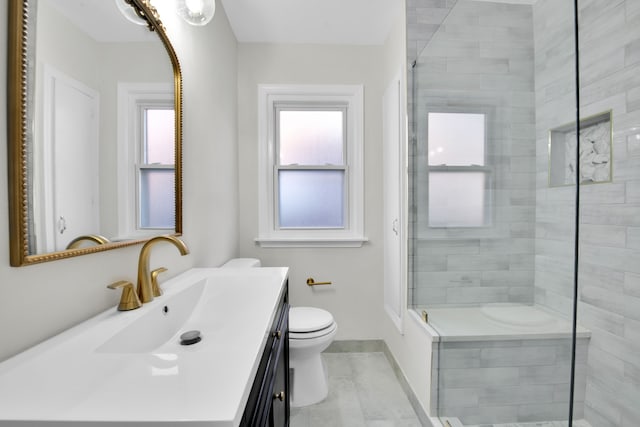 bathroom with toilet, vanity, and a shower with door