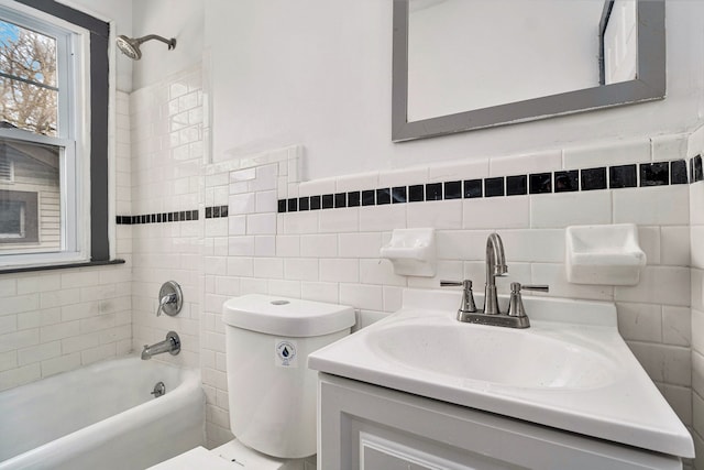 full bathroom featuring vanity, tiled shower / bath combo, tile walls, and toilet