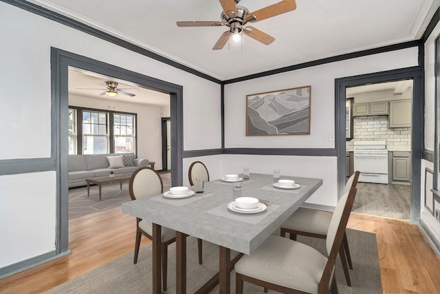 dining space with ceiling fan, light hardwood / wood-style floors, and ornamental molding