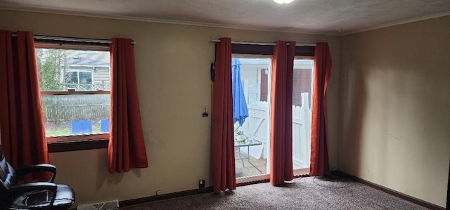 foyer with carpet, a textured ceiling, and crown molding