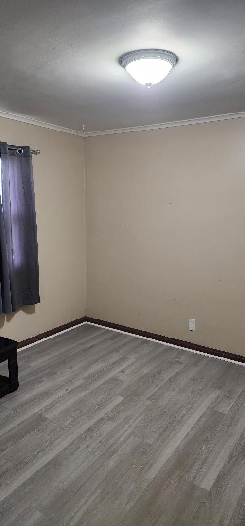 spare room with light wood-type flooring and crown molding