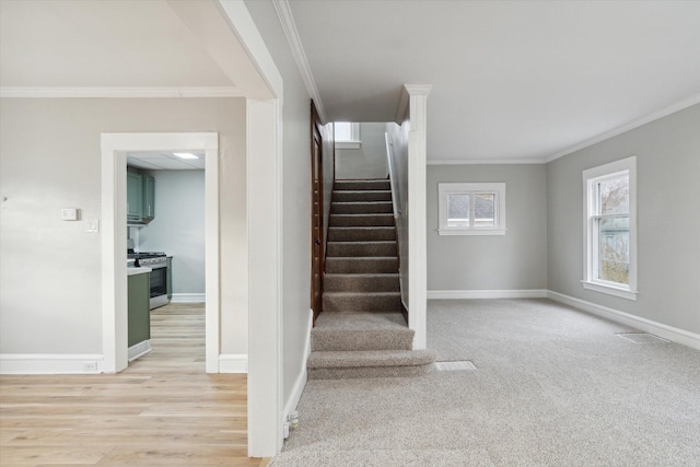 staircase featuring hardwood / wood-style flooring and crown molding