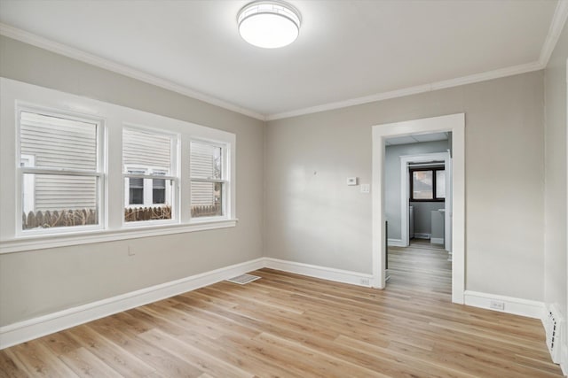 empty room featuring light hardwood / wood-style floors and ornamental molding