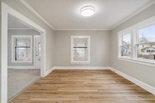 spare room with crown molding and light hardwood / wood-style flooring