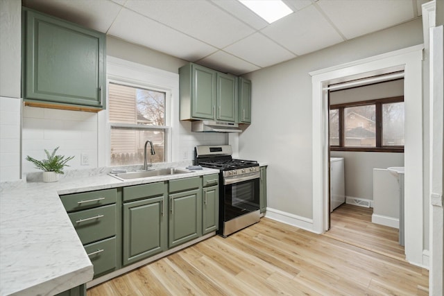 kitchen featuring a wealth of natural light, green cabinetry, stainless steel gas range oven, and sink