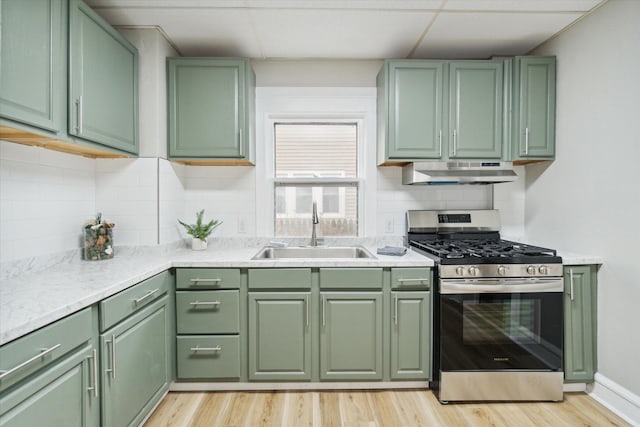 kitchen featuring sink, light wood-type flooring, green cabinetry, and stainless steel range with gas stovetop