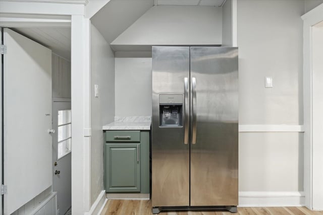 kitchen with lofted ceiling, stainless steel refrigerator with ice dispenser, and light hardwood / wood-style flooring